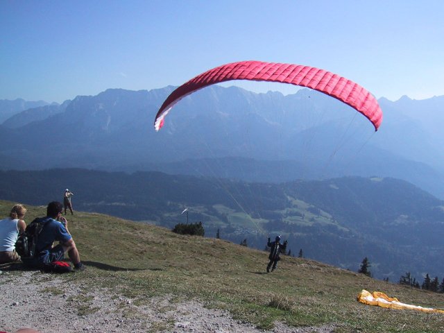 They pull the parasail toward them so it lifts just off the ground. Then they run off the side of the mountain. ;-)