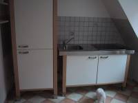 The kitchen as I received it.  On the left is a cabinet housing a refridgerator on top, and storage below.  On the right is the sink, ceramic cooktop, and cupboard underneath.